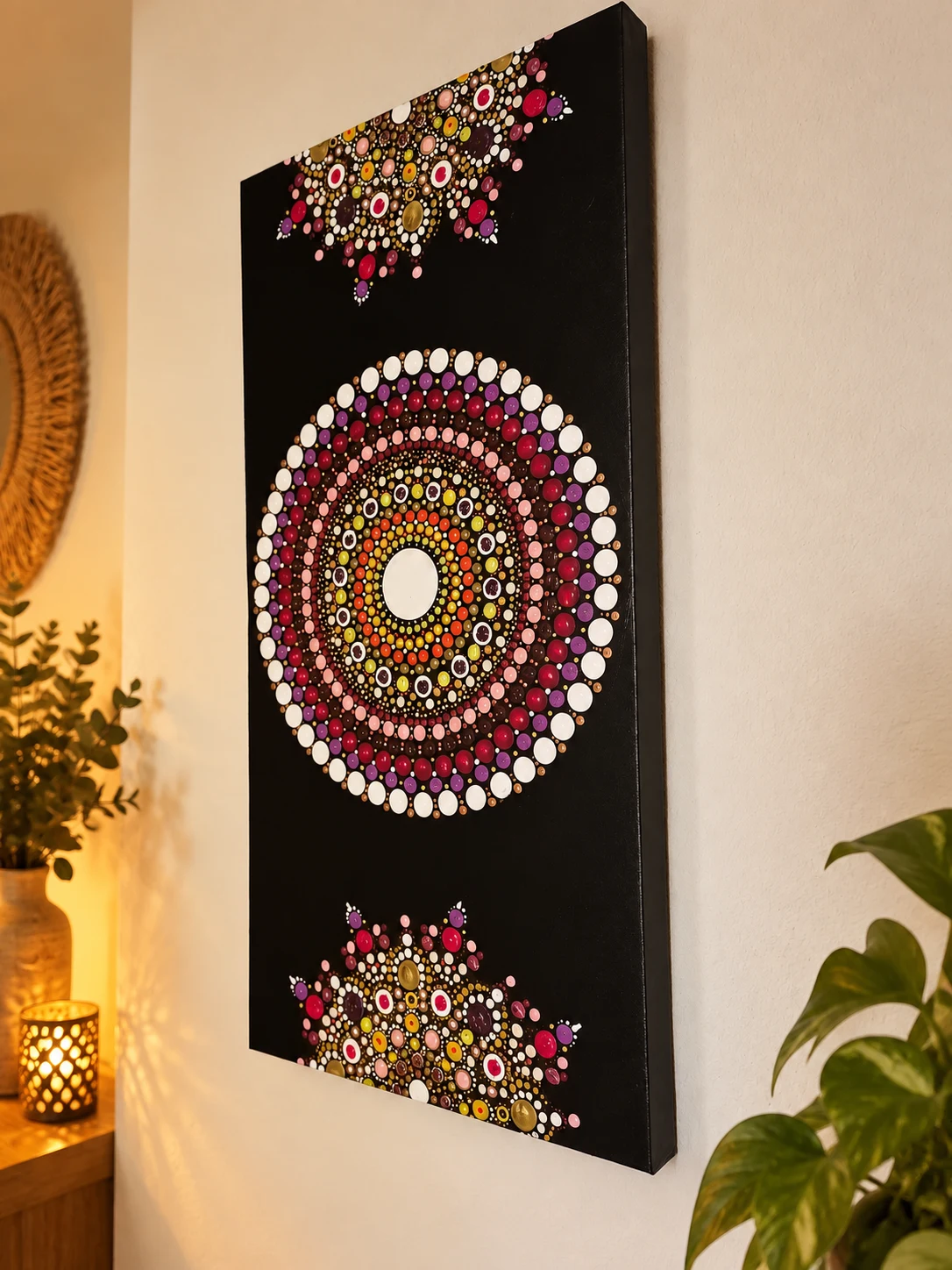 Cuadro vertical negro con un mandala central multicolor y motivos circulares en los extremos